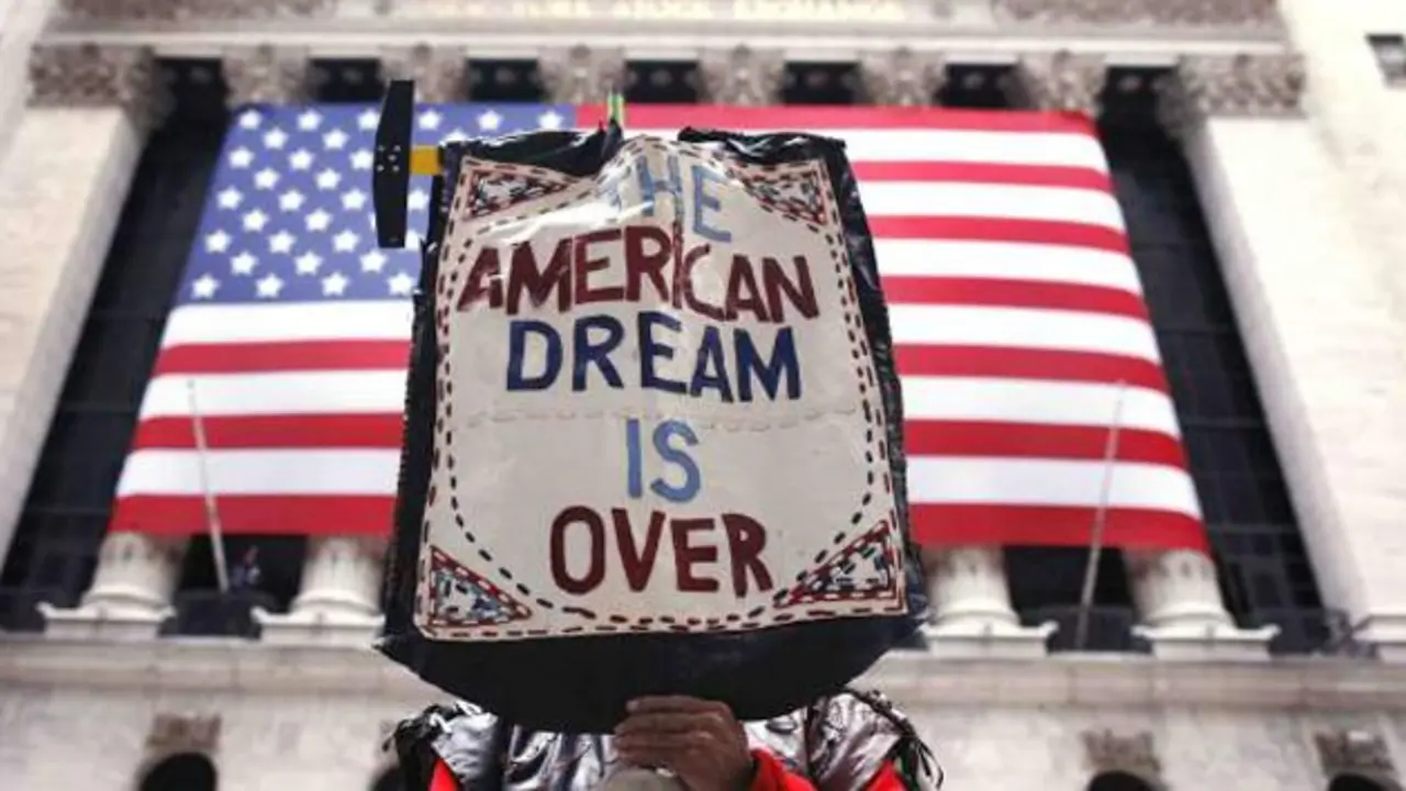 Un manifestante levantando un cartel que dice: "El sue&ntilde;o americano se acab&oacute;", frente a la sede de la Bolsa de Wall Street, en Nueva York, EE UU. / NBC
