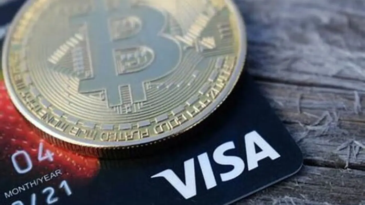 Tarjeta VISA junto a una criptomoneda. / Bircoindynamic.
