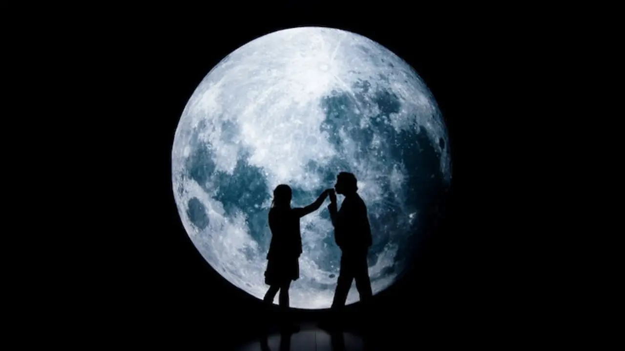 Pareja delante de la luna.