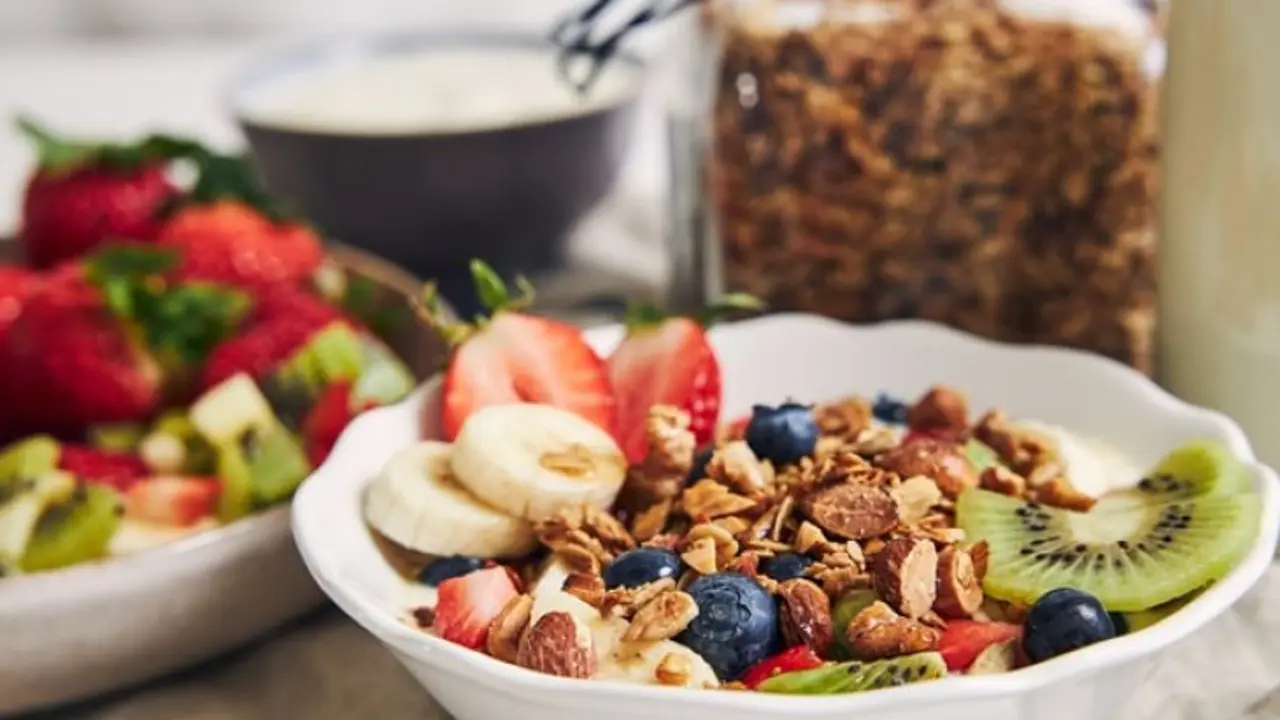 Taz&oacute;n de granola, frutas, yogurt, sobre una superficie. / Freepik.
