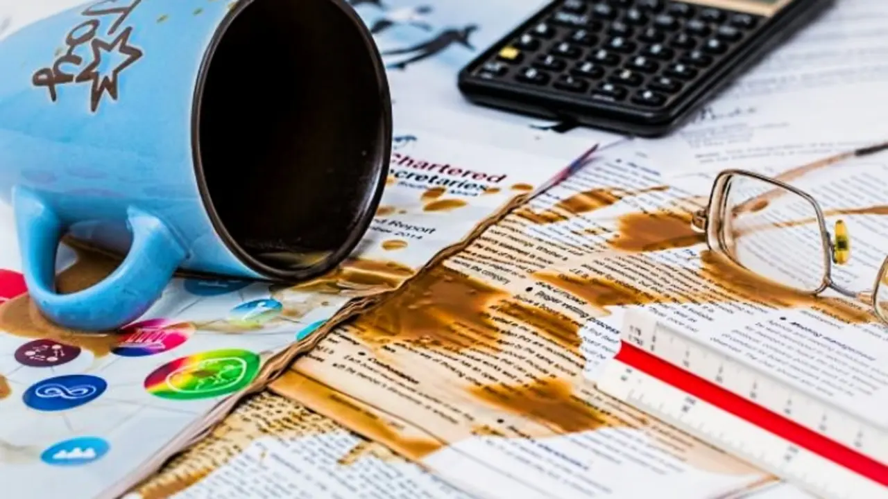 Una taza de caf&eacute; derramada sobre papeles. PxHere