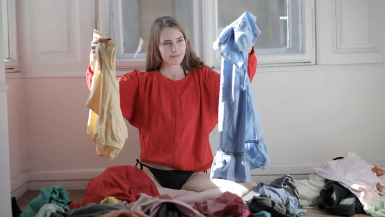 Una chica separando la ropa para lavar. / Pexels.com.