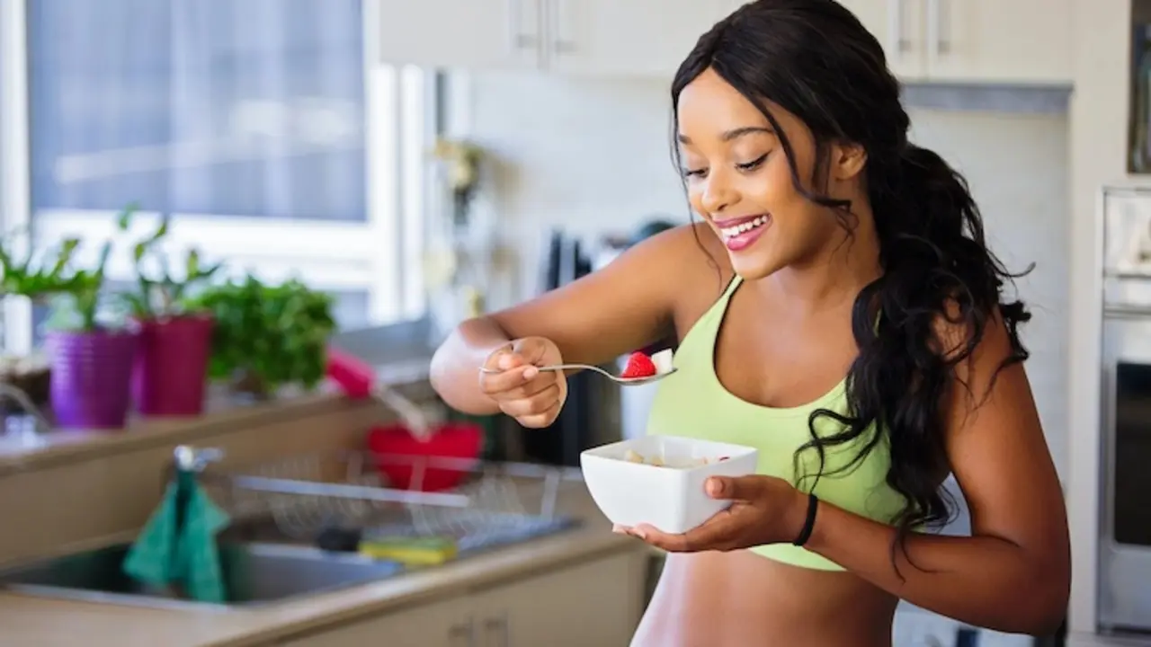 Chica comiendo fruta. / Pexels