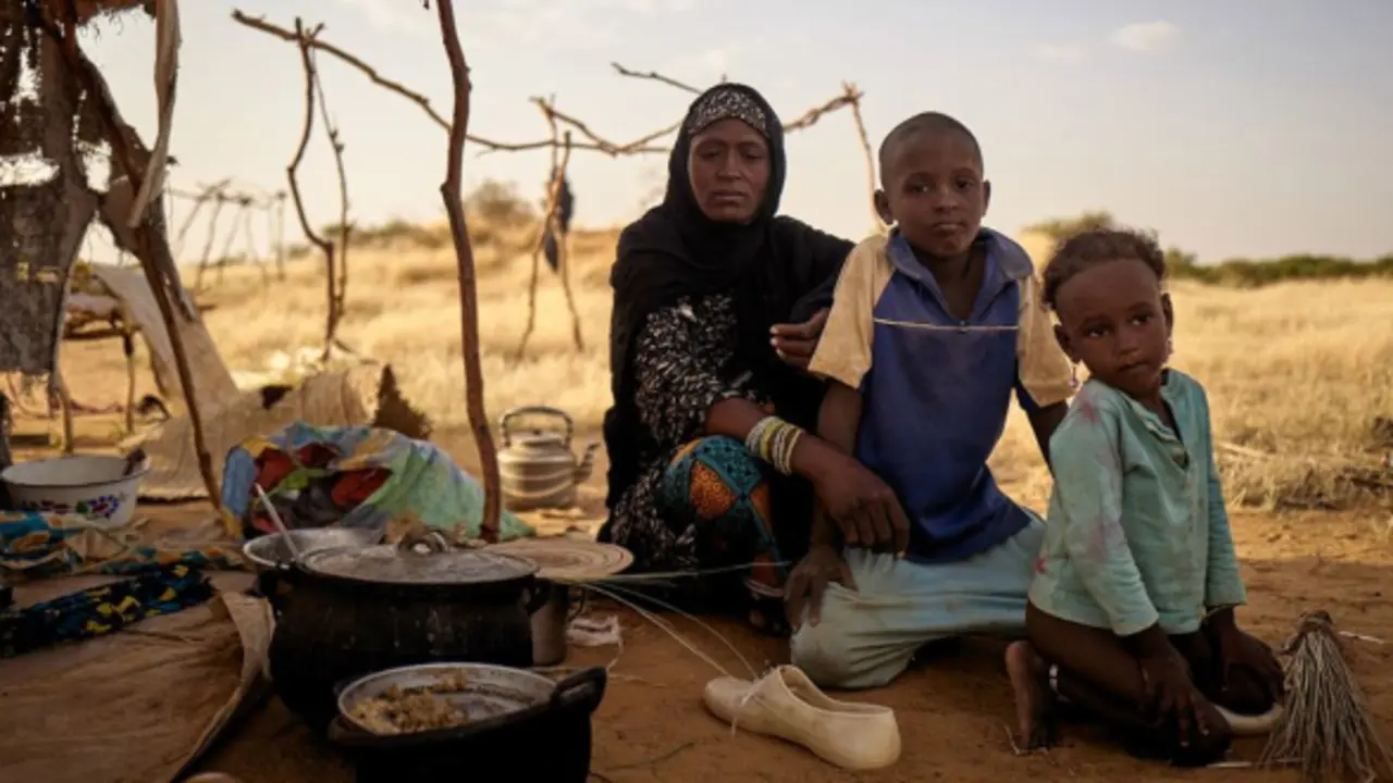 Una familia desplazada sentada frente a su tienda de campa&ntilde;a en un campamento informal de Bagoundi&eacute;, en Mal&iacute; / ONU