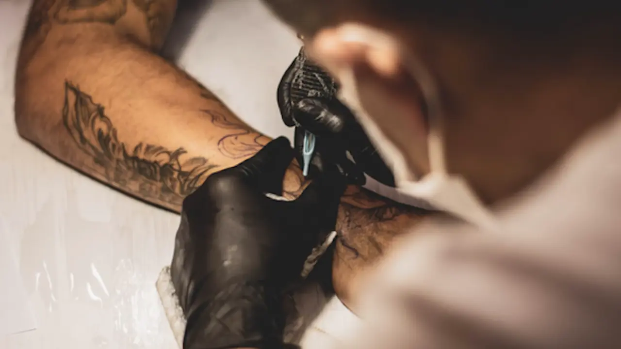 Tatuador haciendo un tatoo.