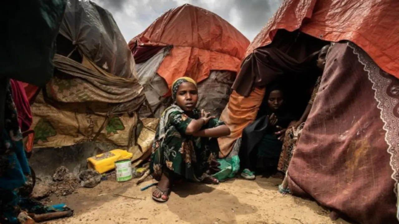 Una ni&ntilde;a sentada frente a la tienda de campa&ntilde;a en la que vive su familia en un campo de desplazados internos en Mogadiscio, Somalia, en octubre de 2022. / UNICEF.