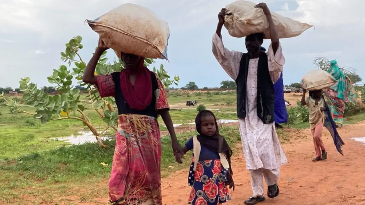 Una familia de Darfur, Sud&aacute;n, huye a trav&eacute;s de la frontera con Chad. / ACNUR.