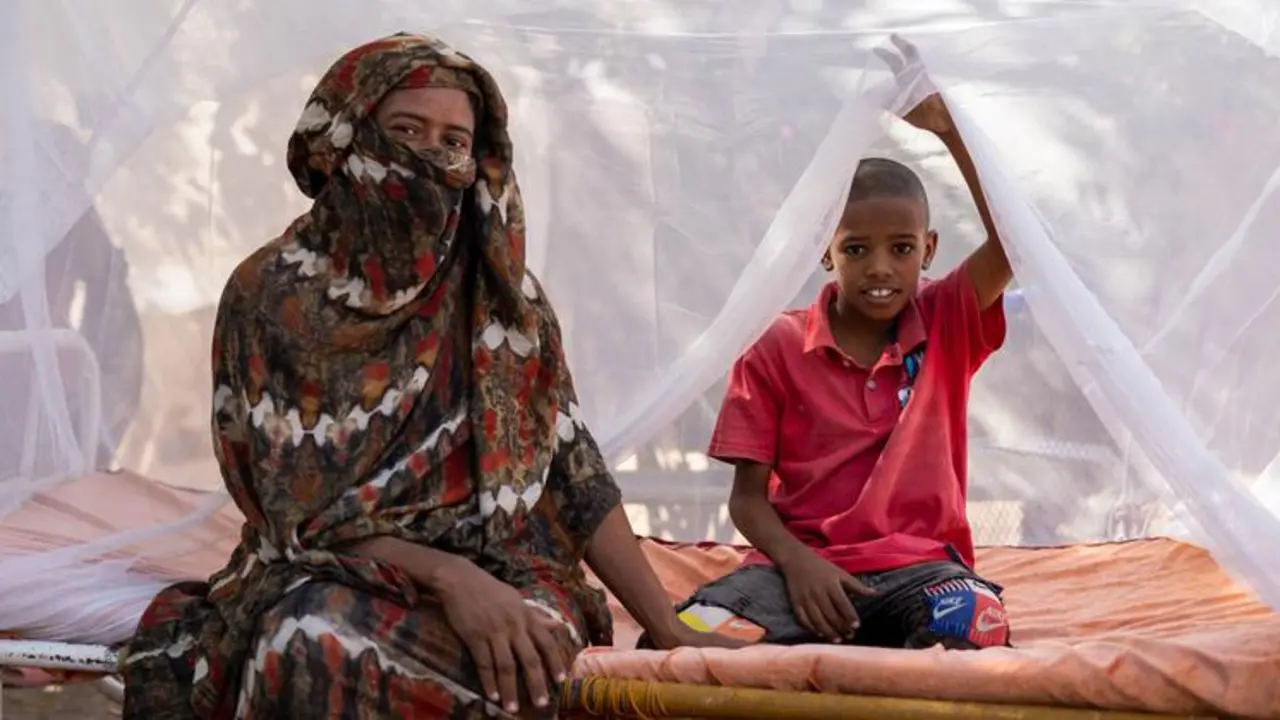 Una madre y su hijo sentados en una cama con mosquiteros tratados con insecticidas de larga duraci&oacute;n distribuidos por UNICEF y sus socios en el estado de Kassala, Sud&aacute;n. / UNICEF.