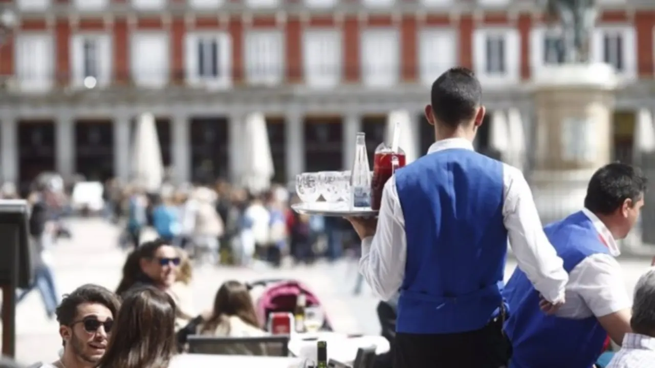 Un camarero sirve bebidas en una terraza. / RR SS.
