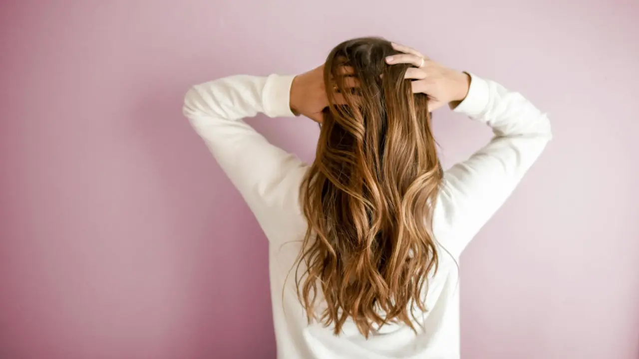 Mujer con cabello limpio, sedoso y sin caspa.