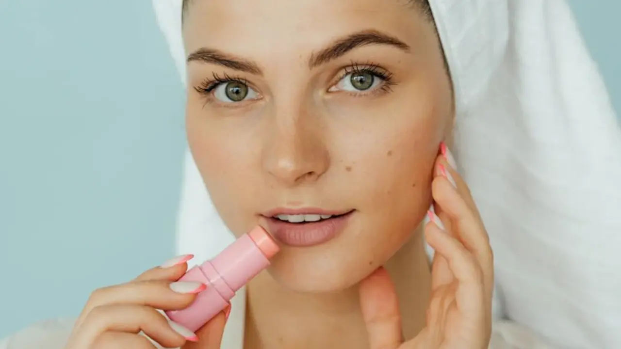 Mujer usando b&aacute;lsamo labial hidratante.