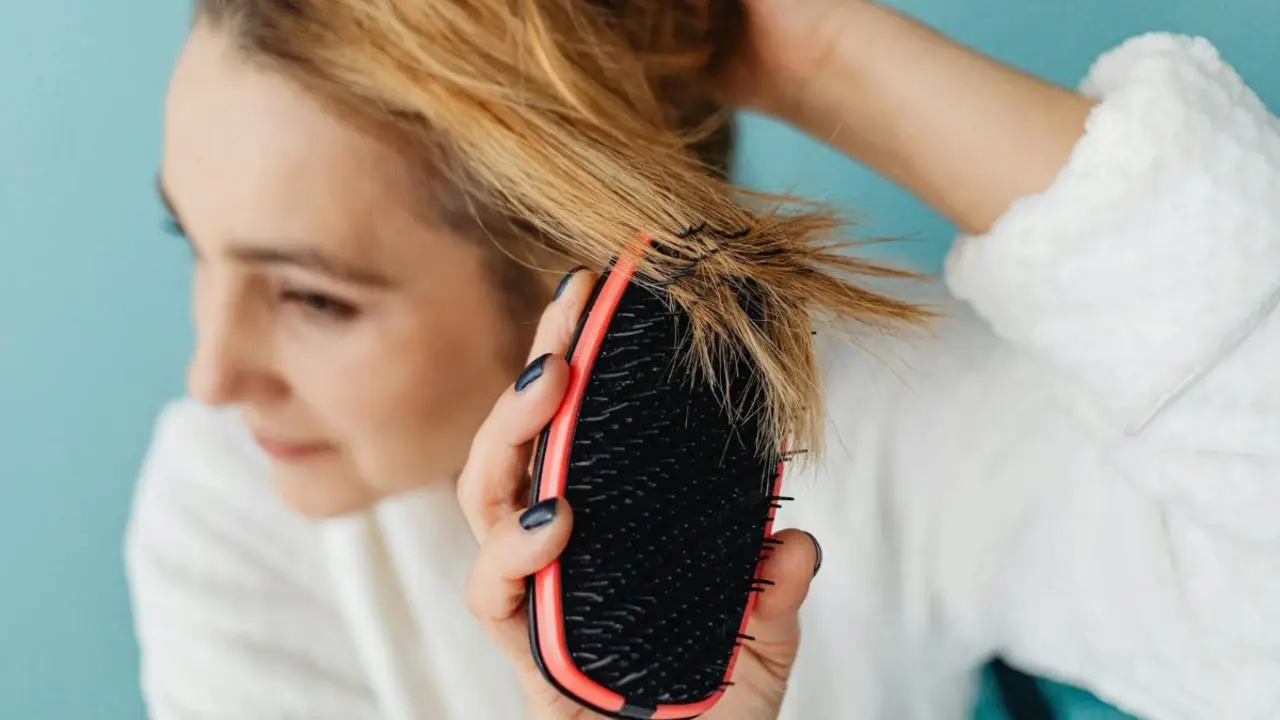 Mujer con cepillo flexible para cabello.