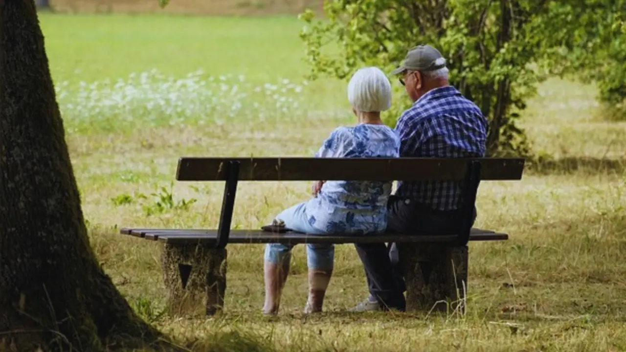 Dos ancianos sentados en una banca. / Pixabay.