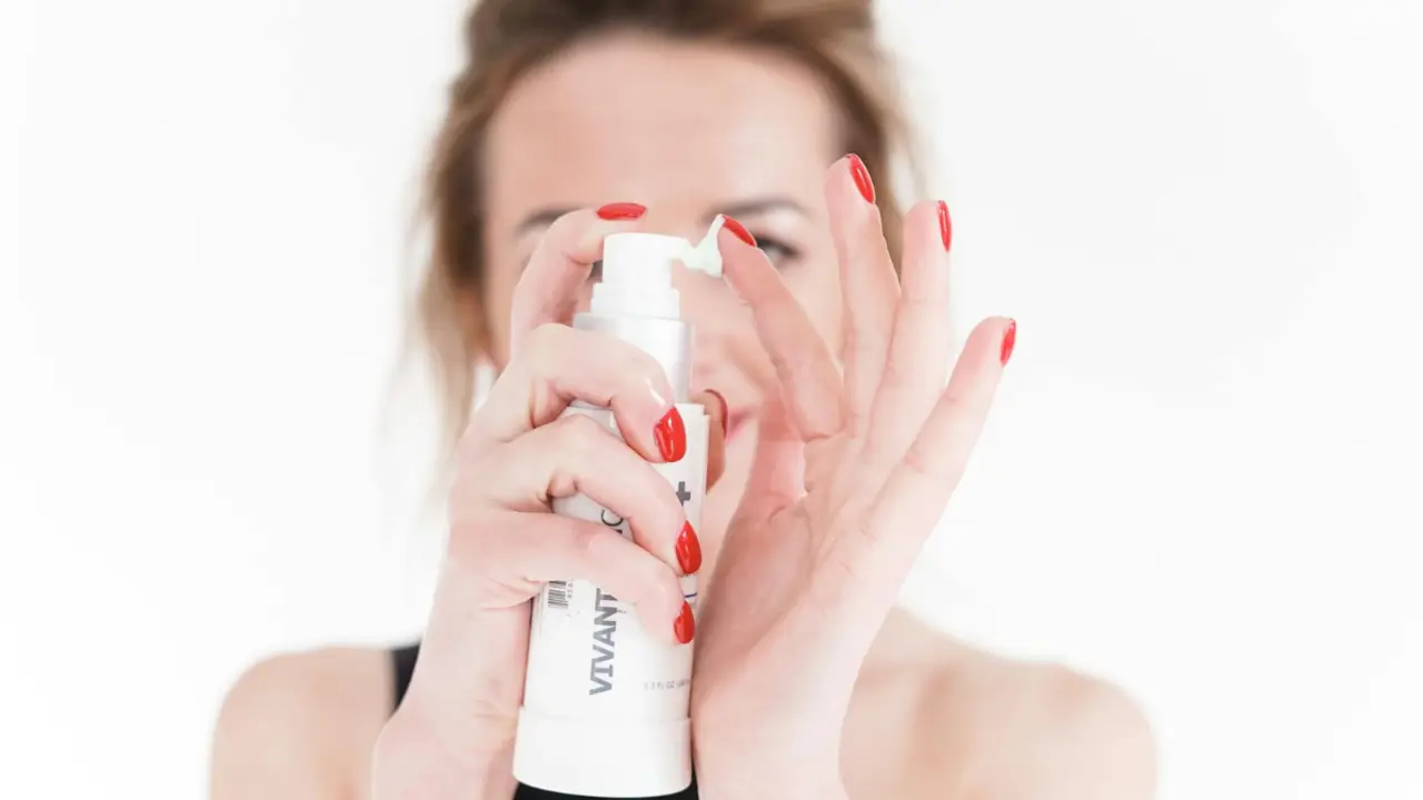 Mujer con envase de mascarilla capilar hidratante.
