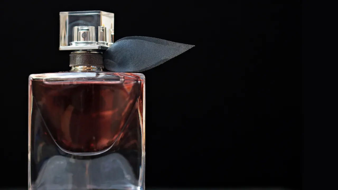 Elegante envase de perfume con fondo oscuro.
