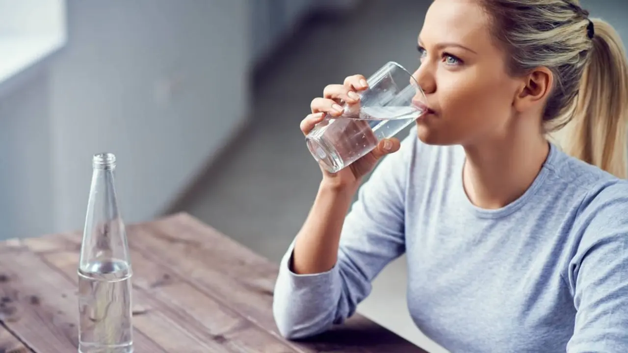 Una mujer toma un vaso de agua. / RR SS.
