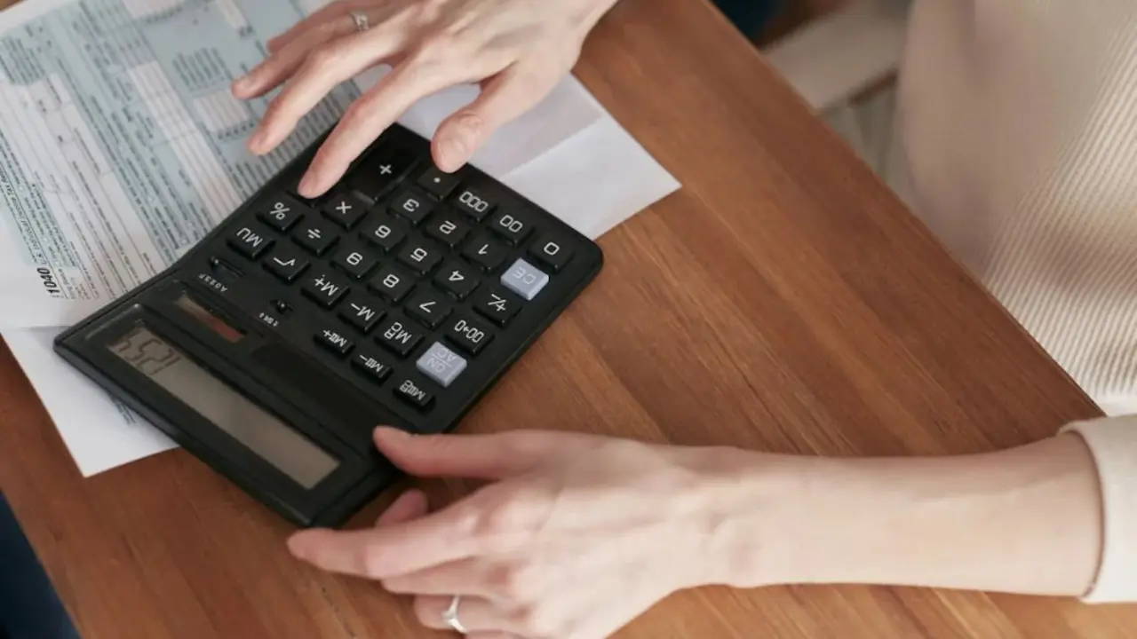 Una mujer usando una calculadora. / Pexels.