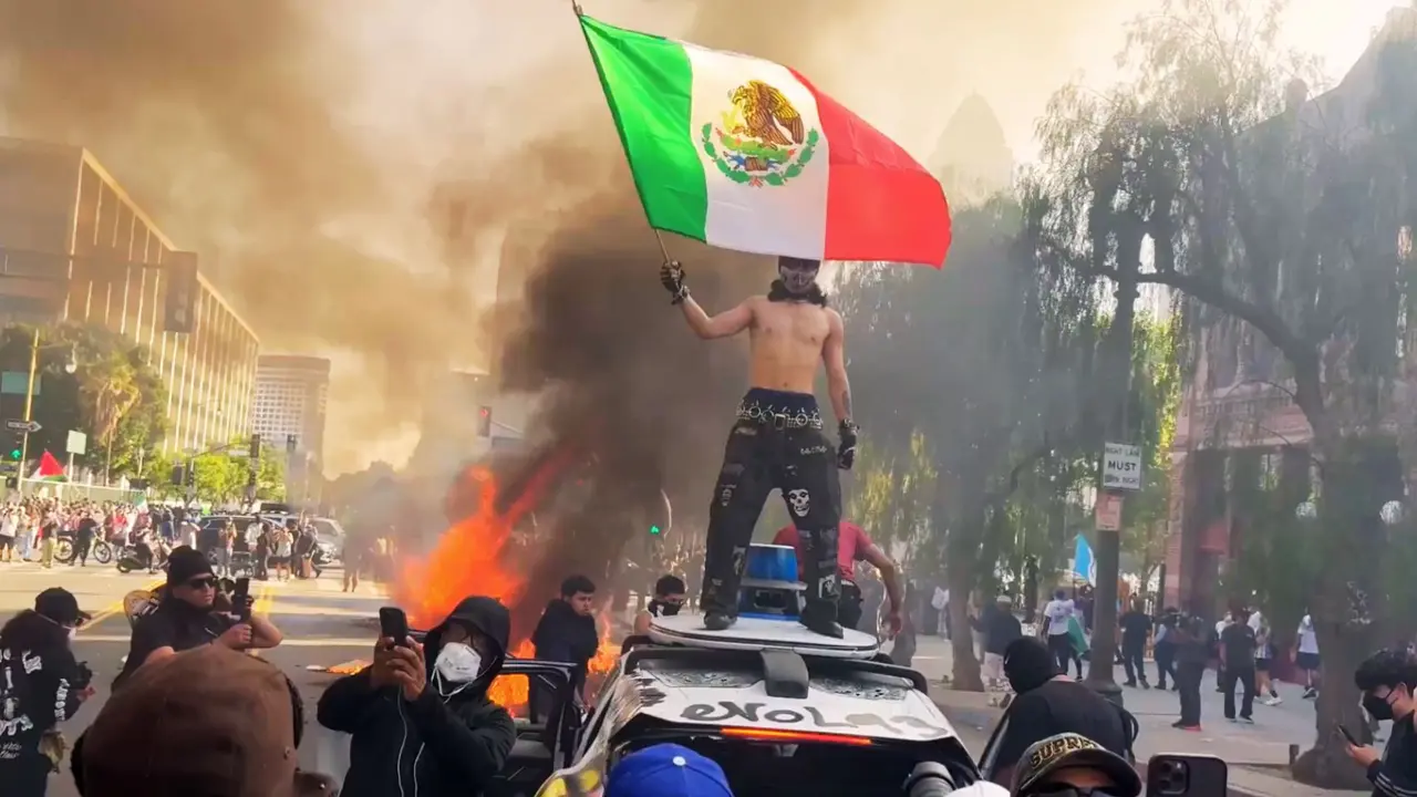 Un hombre durante las protestasen EE UU llevando la bandera de M&eacute;xico. / X.