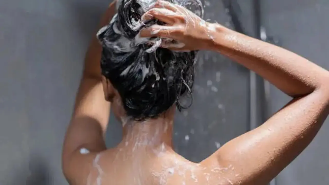 Una mujer lavandose el cabello. / RR. SS.