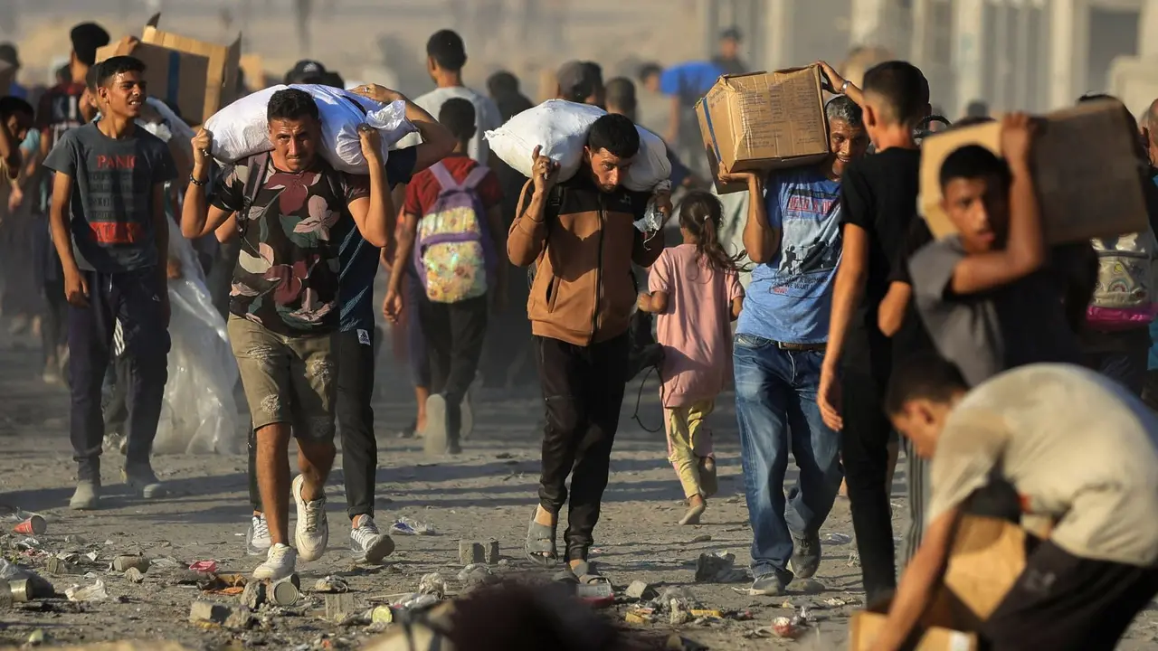 Gazat&iacute;es retiran comida en medio de la guerra. / @AlArabiya_Eng.