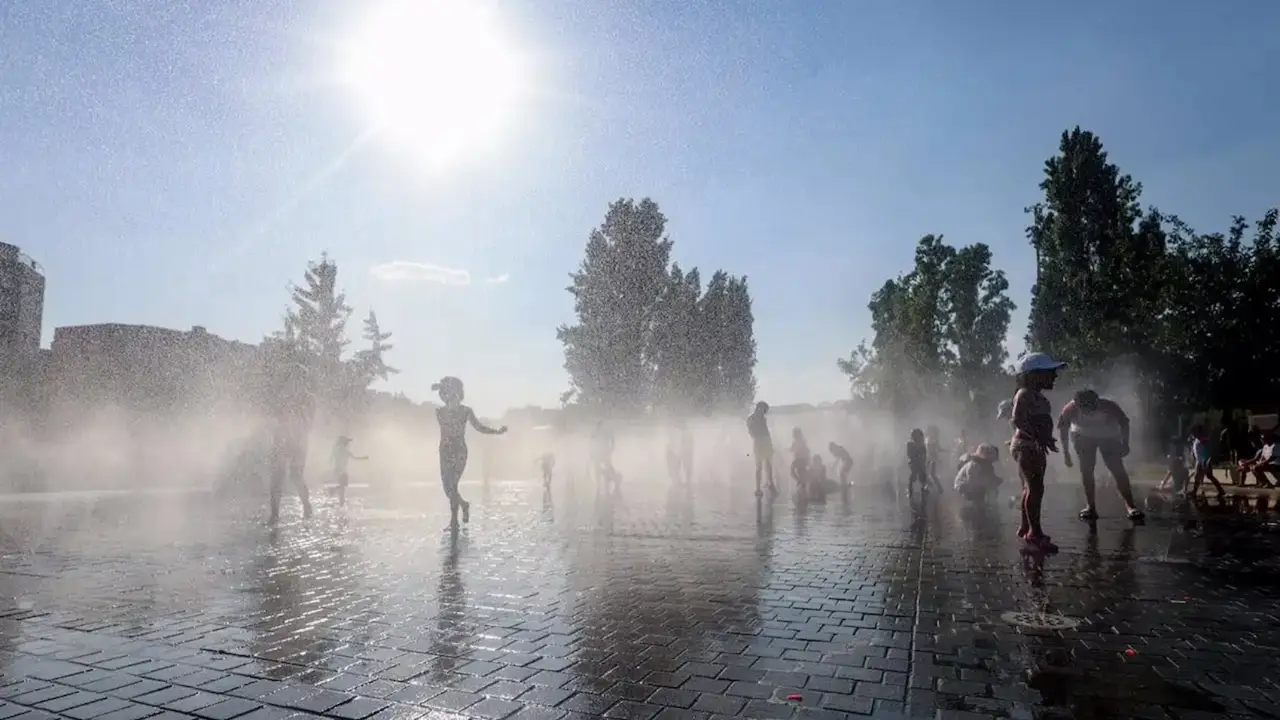 Ni&ntilde;os jugando con el agua para refugiarse del calor. / RR. SS.