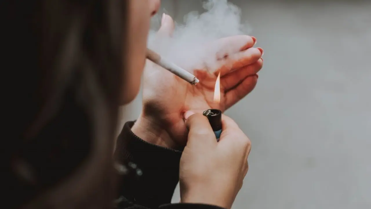 Una mujer fumando. / RR. SS.