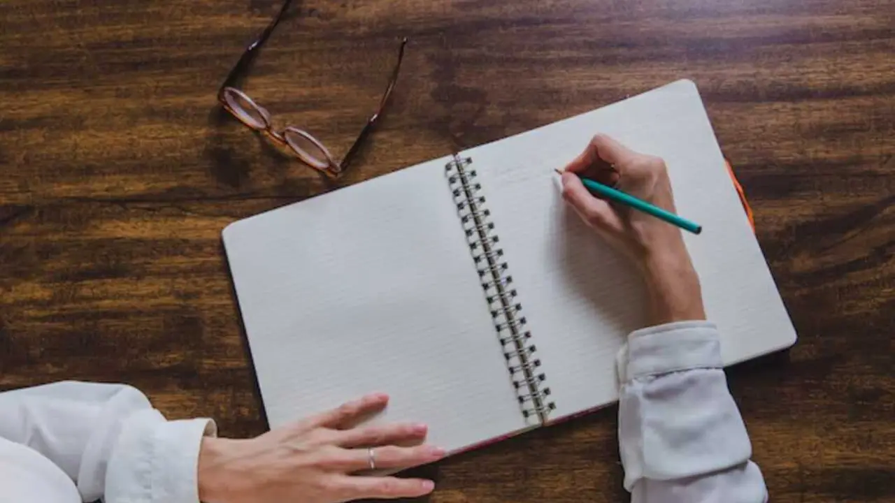 Una persona escribe en su libreta. / Freepik.