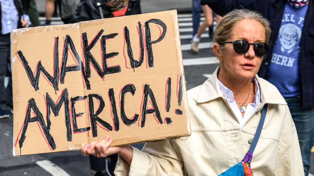 Nueva York, USA, 18 Octubre 2025.  Manifestantes llevan carteles como "Despierta, Am&eacute;rica" durante la protesta del d&iacute;a  "NO REYES" en Nueva York.  Foto:  Enrique Shore