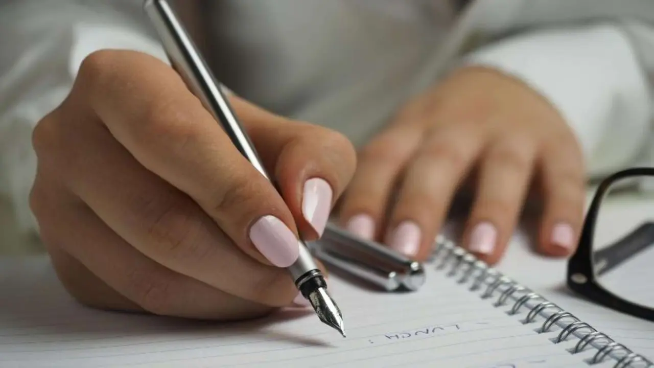 Una mujer escribiendo una lista. / RR. SS.