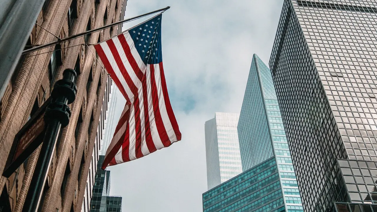 Bandera de EE.UU. colgada en un edificio de Wall Street. / Freepik.