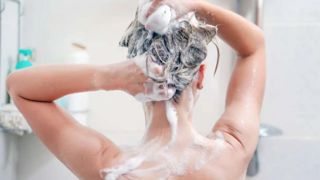 Una mujer lavandose el cabello. / iStock.