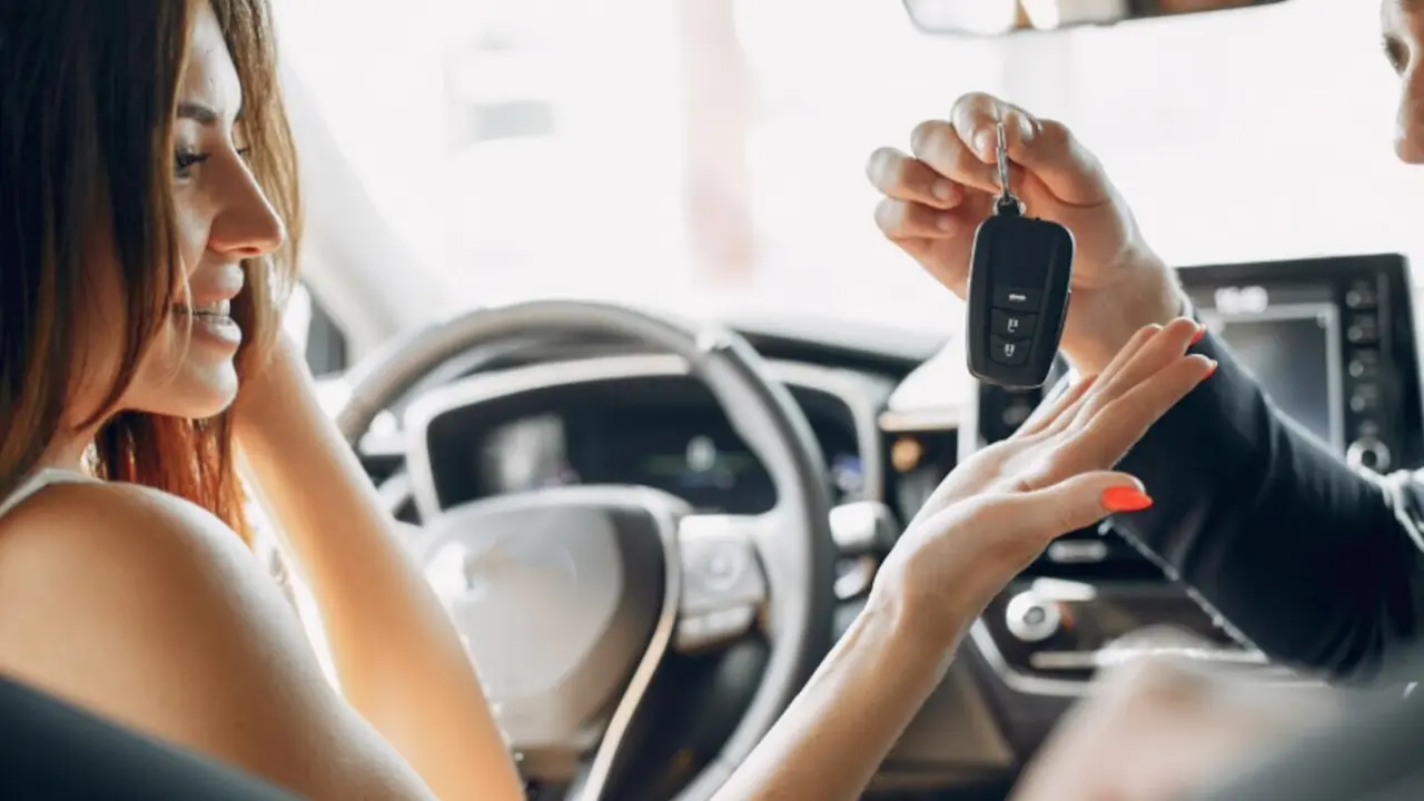 Mujer cogiendo un mando del coche.