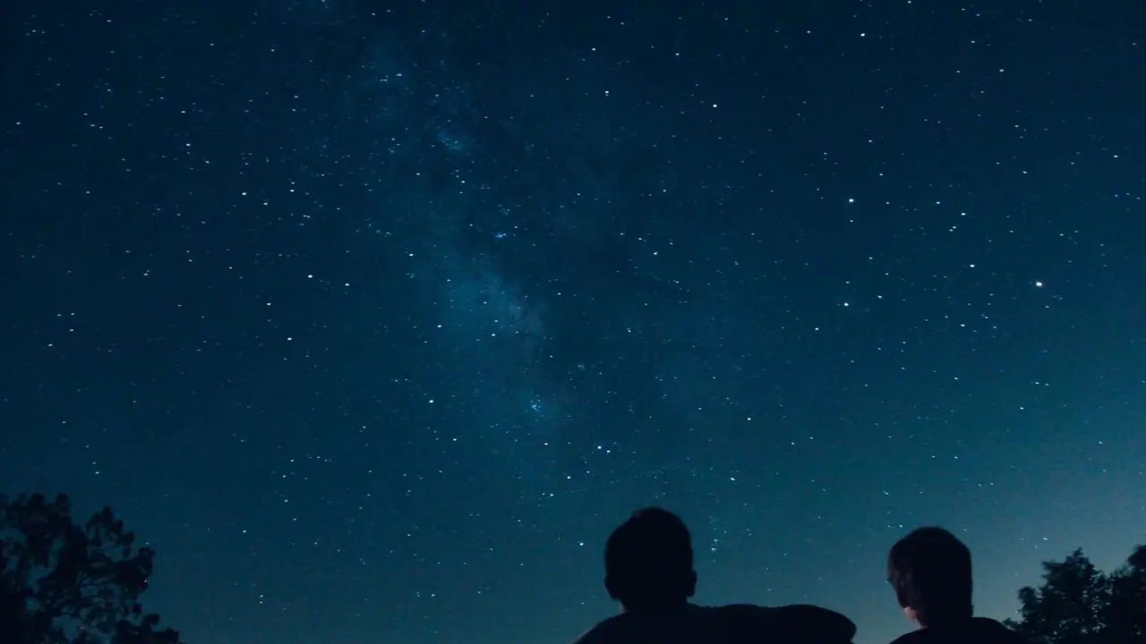 Dos personas mirando las estrellas. / Unsplash.