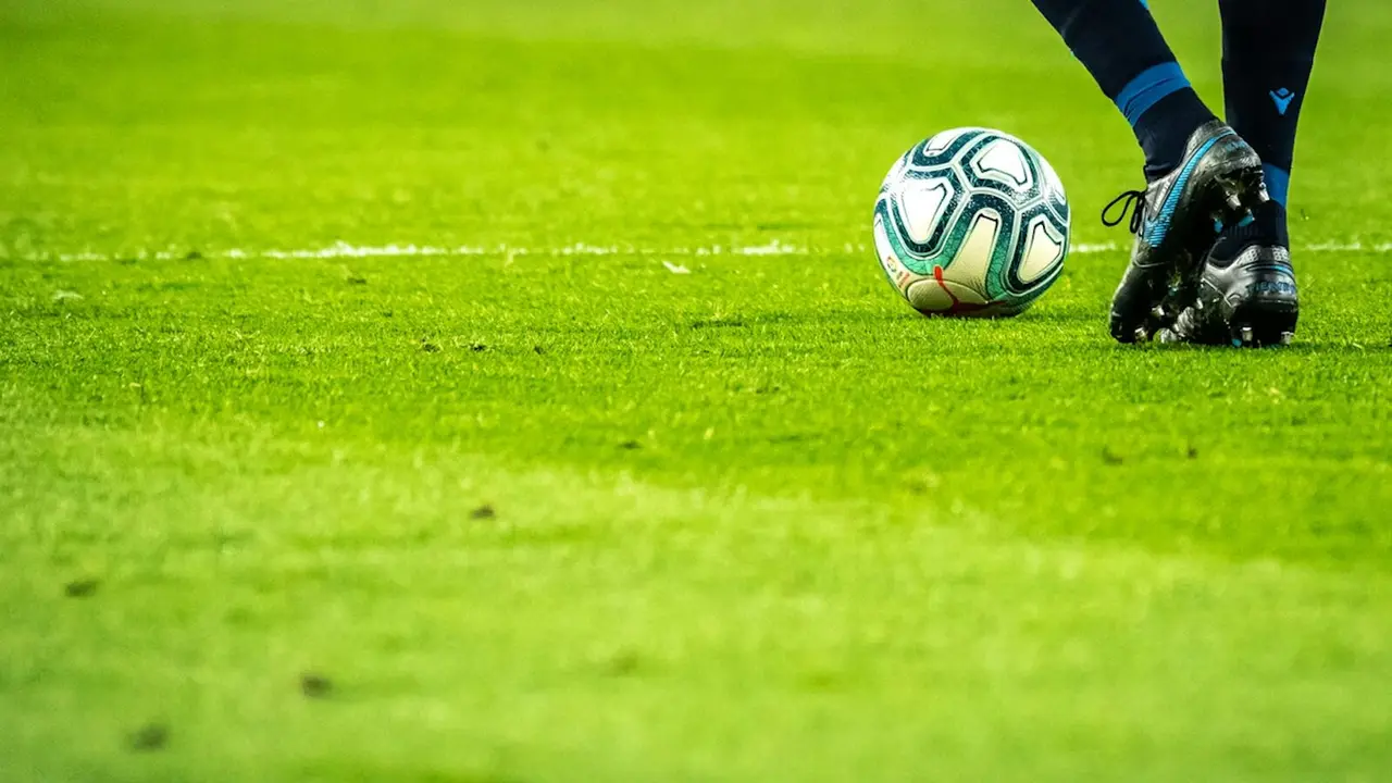 Jugador de fútbol con balón.