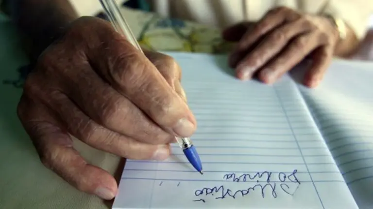 Una persona mayor aprende a escribir.