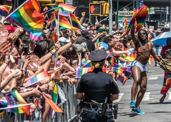 Un participante baila en la Quinte Avenida en frente de un oficial de policía durante la marcha del Orgullo Gay. Foto: Enrique Shore