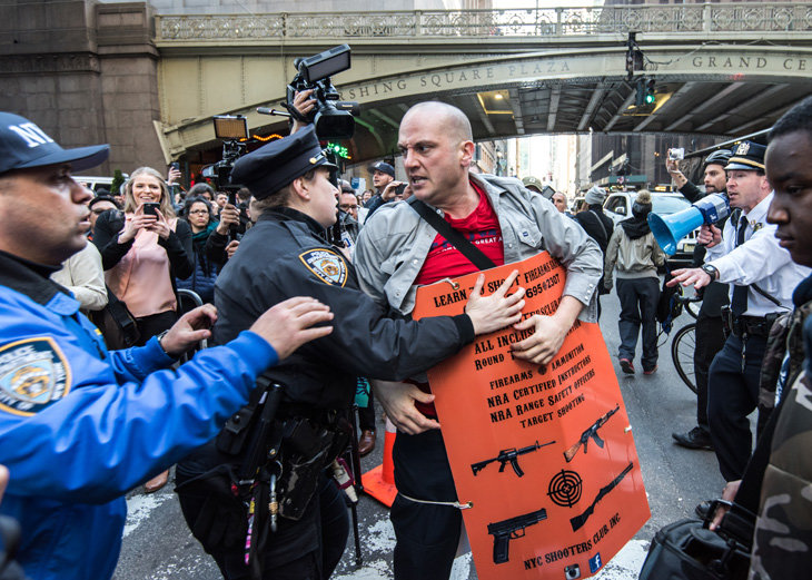 La policia expulsa a un hombre que portaba carteles promoviendo el uso de armas y la ultra conservadora Asociación Nacional del Rifle cuando intentaba provocar un enfrentamiento con manifestantes anti-Republicanos en Nueva York el 14 de Abril. Foto: Enrique Shore