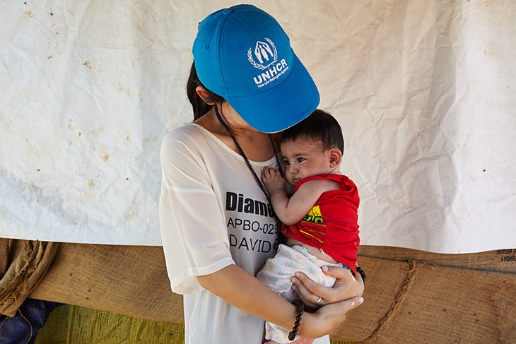 UNHCR staff member, Eujin Byun, holds a young Syria refugee in an informal tented settlement in Terbol, in the Bekaa Valley, in Lebanon. She says,