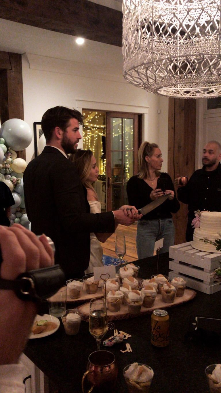 Liam Hemsworth y Miley Cyrus cortando una tarta. RR SS