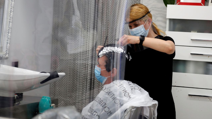 Personas con mascarillas en una peluquería.