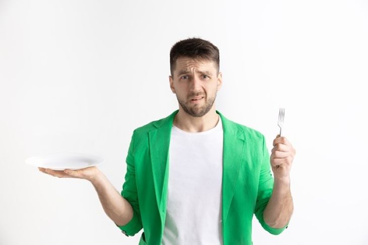 Hombre confundido con el plato vacío /Freepik