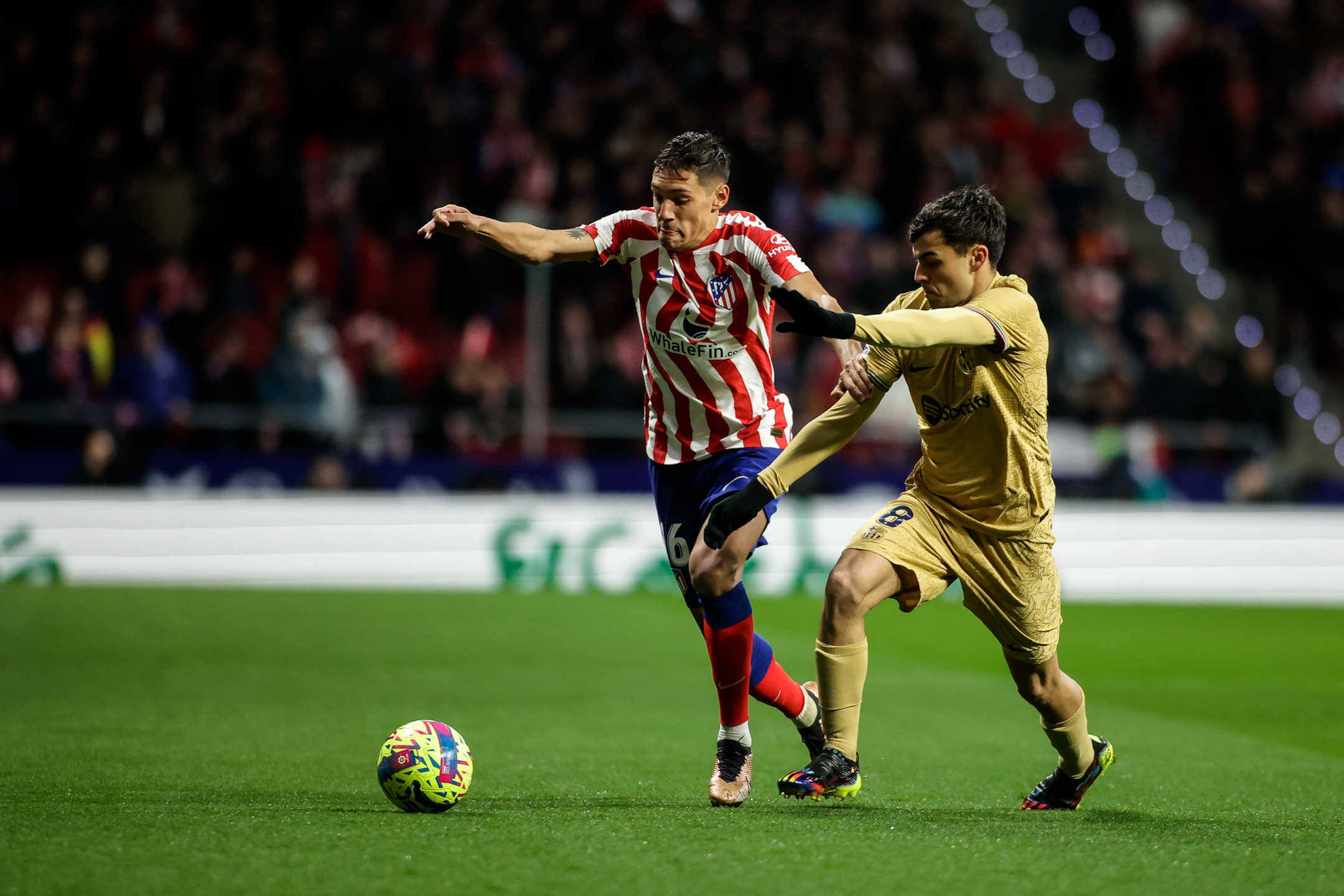 Nahuel disputando un balón con Pedri. / @Atleti