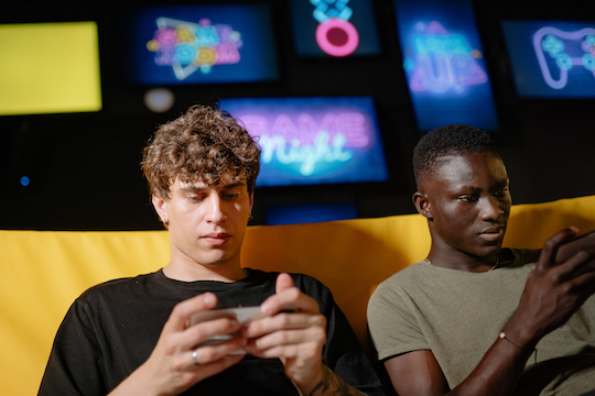 Dos jóvenes jugando con el móvil. / Pexels