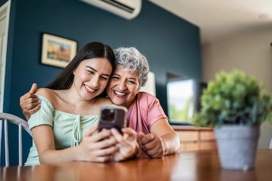Dos mujeres mirando una pantalla de móvil. / iStock